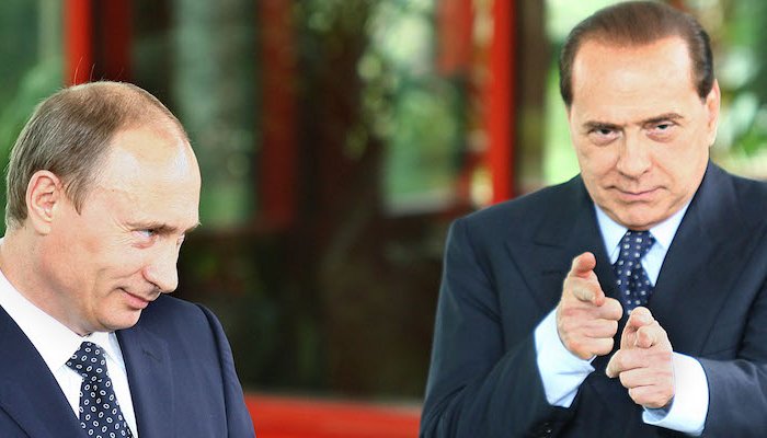 Vladimir Putin e Silvio Berlusconi, che punta le dita come due pistole verso l'obiettivo